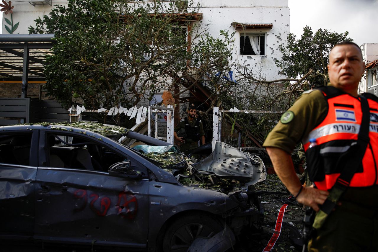 Emergency personnel stand near a damaged car at a site of houses damaged following a rocket attack from Lebanon, in Kiryat Bialik, Israel, on September 22. 