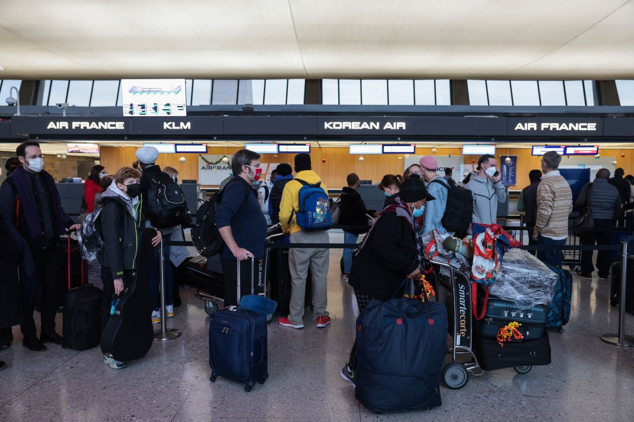 Passengers wait in line to check in for their flights at the Dulles International Airport on December 27. Thousands of flights have been canceled as a surge in Covid-19 cases impacts airline staff.