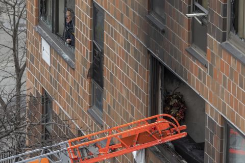 A ladder leads up to a window after a fatal fire at an apartment building in the Bronx on Sunday.