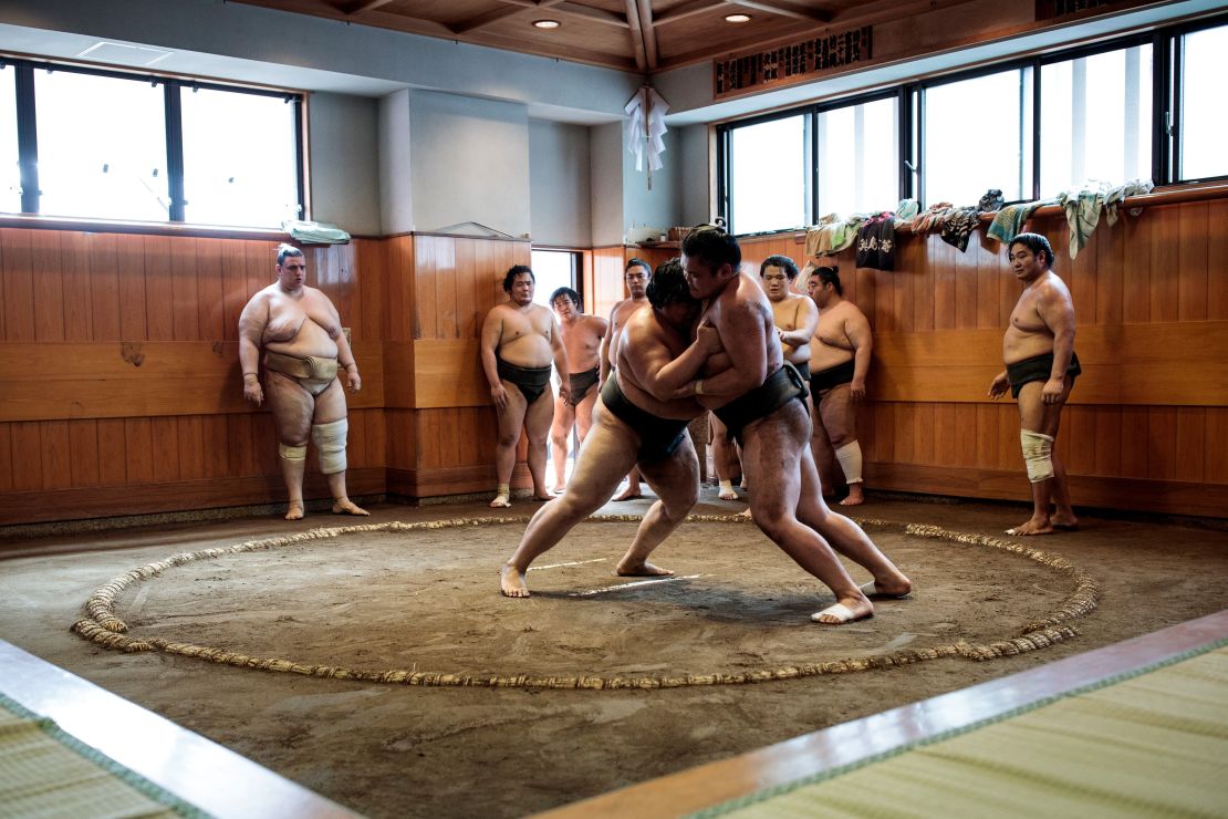 Sumo wrestlers try to push each other out of the ring or "dohyo" during a training session at a stable in Tokyo.