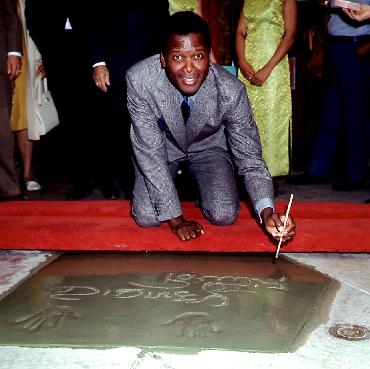 Poitier signs his name and leaves his handprints at the famous Grauman's Chinese Theatre in Hollywood.
