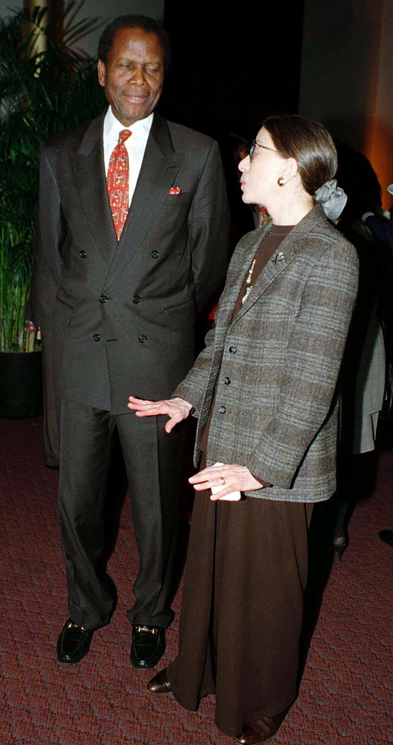 Poitier chats with Supreme Court Justice Ruth Bader Ginsburg before the premiere of the film "Mandela and de Klerk" in 1997.