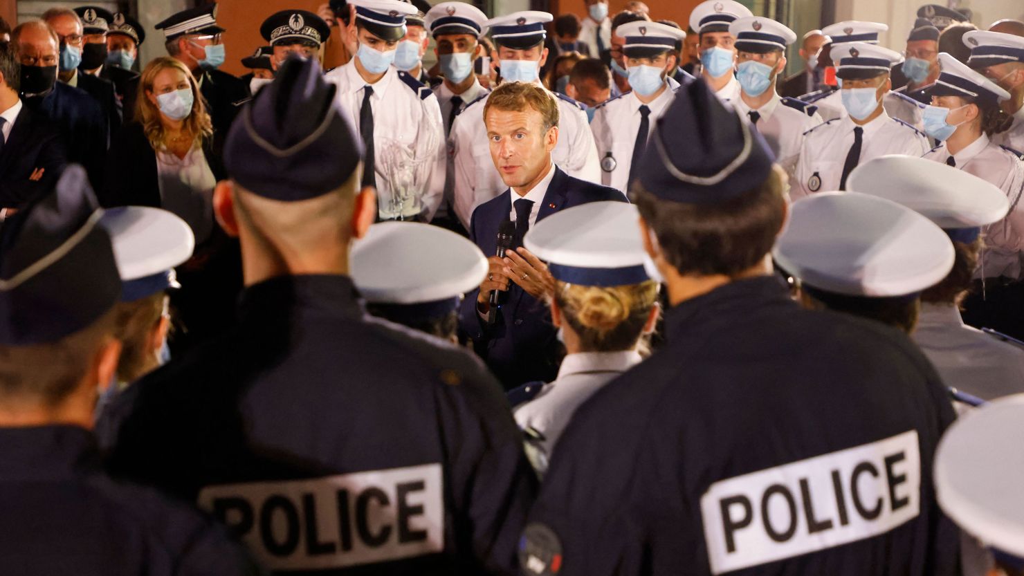 French President Emmanuel Macron talks to police officers during a visit to a police station in northern Marseille on September 1, 2021. 