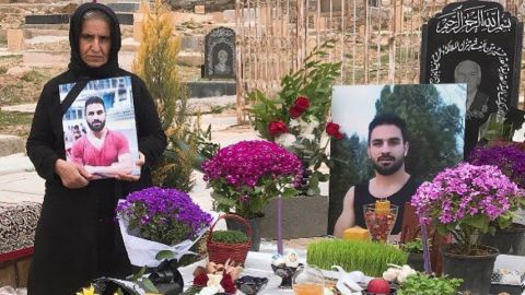 The mother of Navid Afkari, the wrestling star executed by the Iranian government, says her family still has "no peace" over a year since her son's death. Navid's mother (left) stands by Navid's grave in March 2021 in Shiraz, Iran.