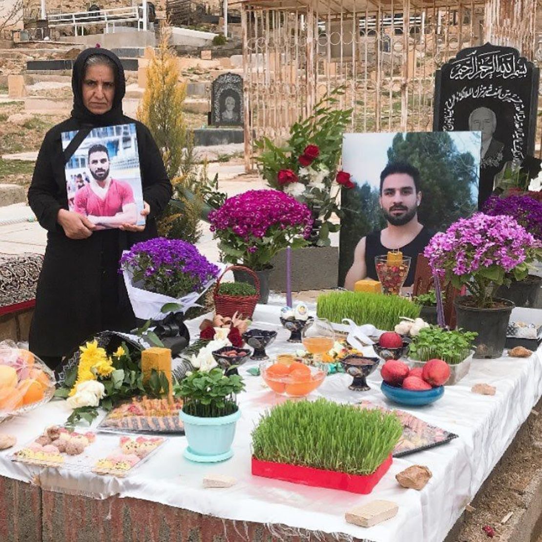 The mother of Navid Afkari, the wrestling star executed by the Iranian government, says her family still has "no peace" over a year since her son's death. Navid's mother (left) stands by Navid's grave in March 2021 in Shiraz, Iran.