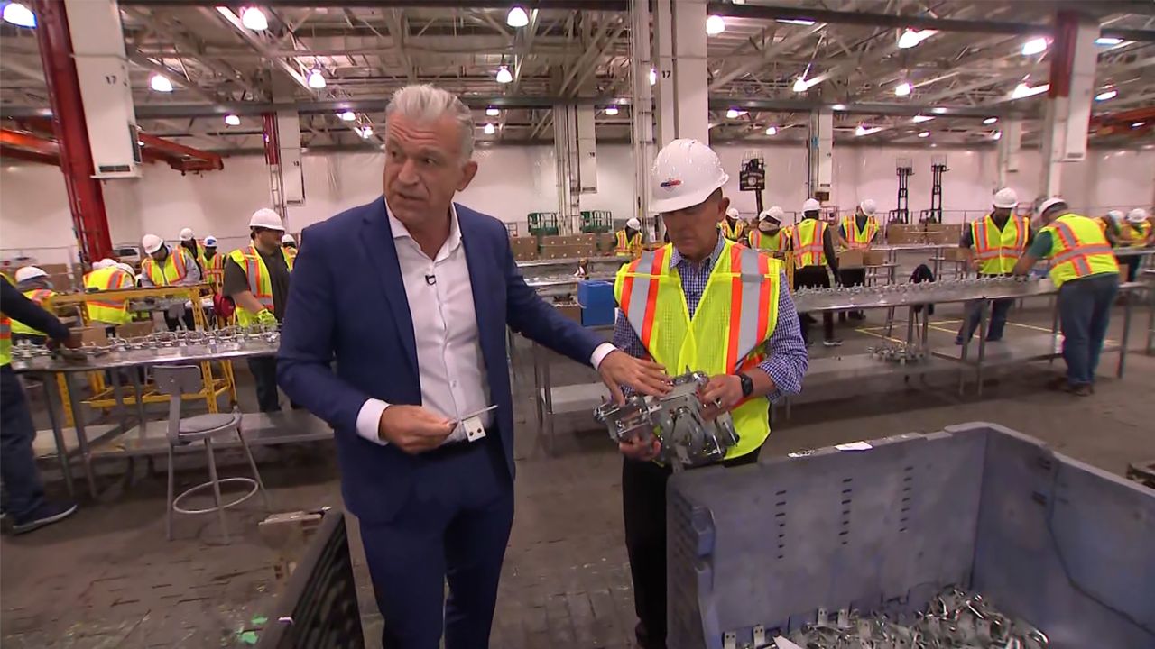 Dylan Ratigan, left, details a component near the assembly line.