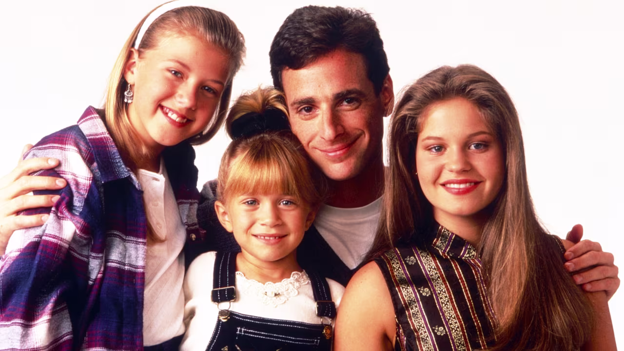 Left to right: Jodie Sweetin, Mary-Kate Olsen, Bob Saget, and Candace Cameron Bure pose for a promotional photo for the TV show Full House in 1993.