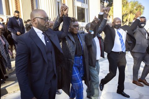 Ahmaud Arbery's mother Wanda Cooper-Jones, center, walks out of the Glynn County Courthouse surrounded by supporters after a judge sentenced Greg McMichael, his son, Travis McMichael, and a neighbor, William "Roddie" Bryan to life in prison, Friday, January, 7, 2022, in Brunswick, Georgia.