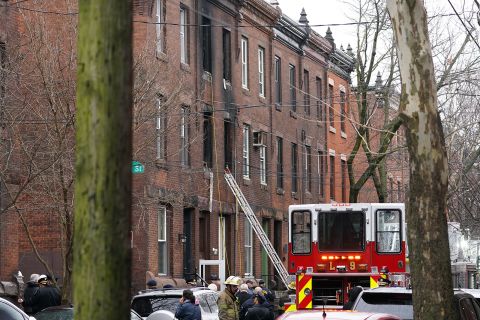 Philadelphia firefighters work at the scene of a deadly row house fire on Wednesday.