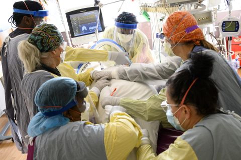 Respiratory therapist, back center, works with a team of critical care nurses and assistants to supine a critically-ill COVID patient in the South Seven Intensive Care Unit on Wednesday, December 8th, at North Memorial Health Hospital in Robbinsdale, Minn. 
