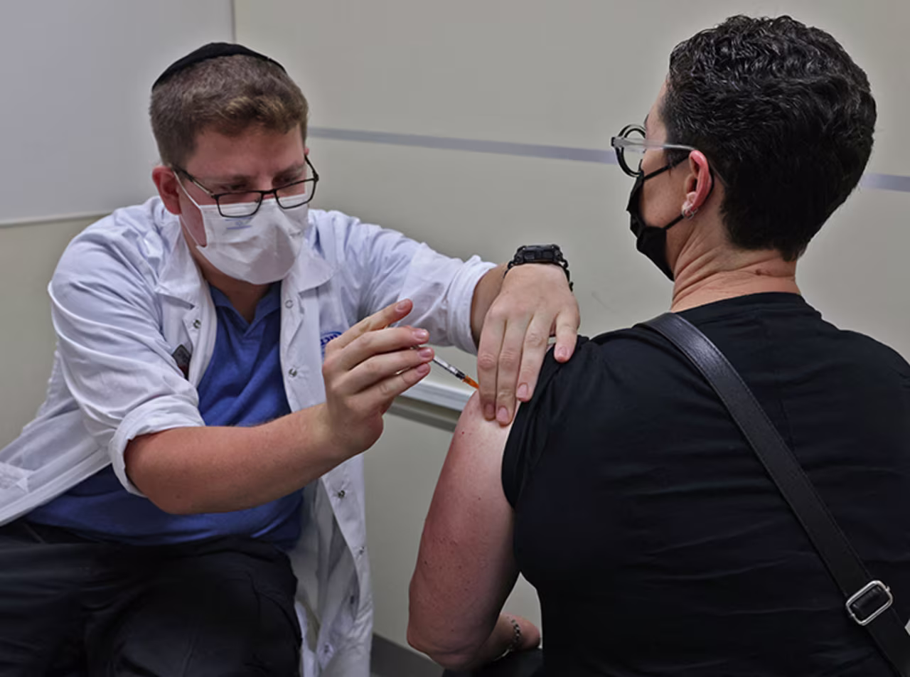 An Israeli health worker administers a third dose of the Pfizer-BioNtech COVID-19 vaccine at the Maccabi Health Service in Jerusalem on August 20, 2021 when Israel launched its campaign to give booster shots to people aged over 40, in a bid to stem spiking infections driven by the Delta variant. 