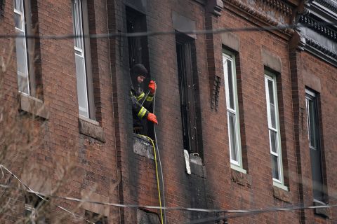 A Philadelphia firefighter works at the scene of a deadly row house fire on Wednesday.
