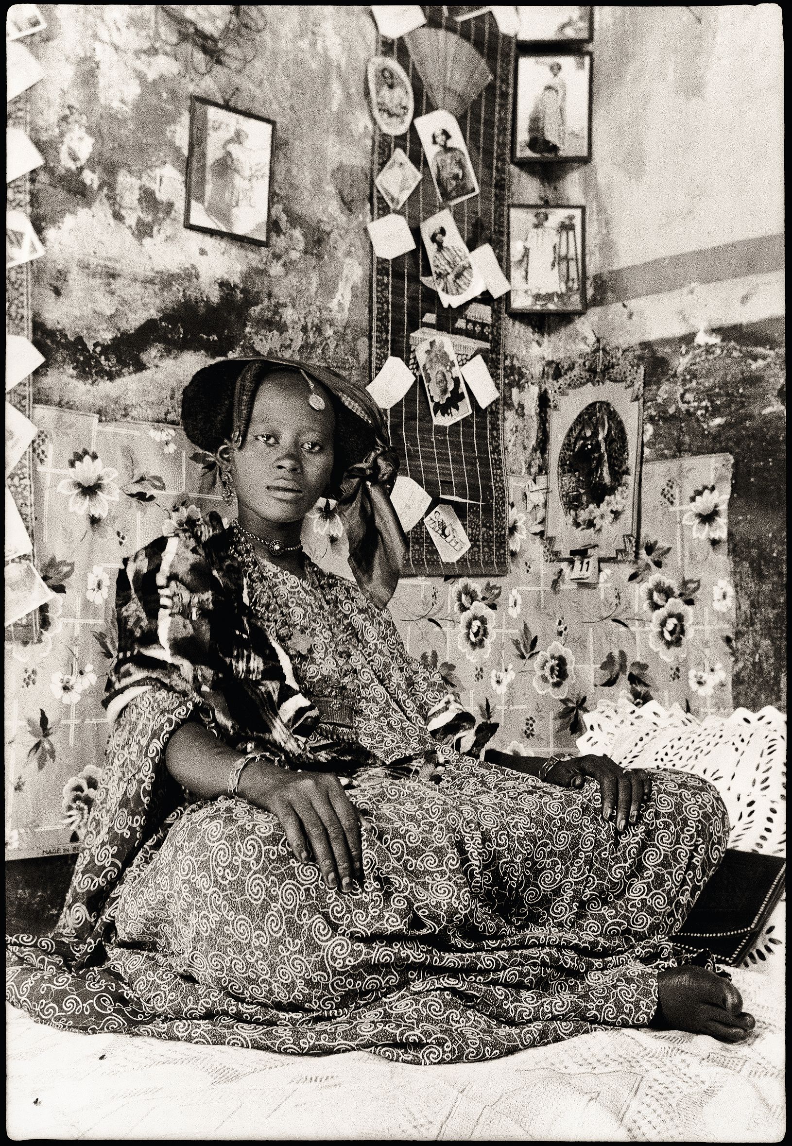 “Portrait of Mrs. Fatou Thioune, Saint Louis,” by Macky Kane, c.1939–1941. This photograph shows Thioune posing in front of her “xoymet,” a Wolof word for a photographic collage associated with brides in the lead up to their wedding.