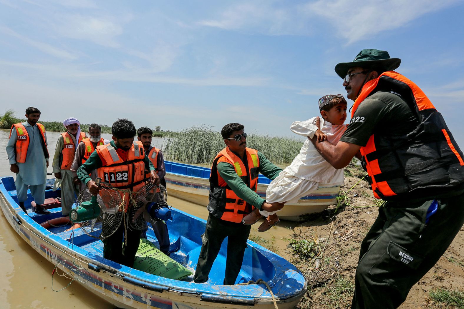Emergency workers rescue a child from a flooded village following heavy rains in the Taunsa district of Pakistan's Punjab province on July 16.