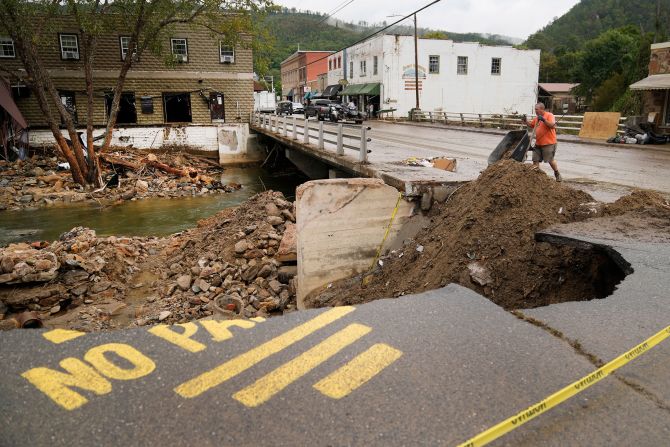 Len Frisbee dumps a wheelbarrow of dirt as he helps with clean up in Hot Springs, North Carolina, on Tuesday.