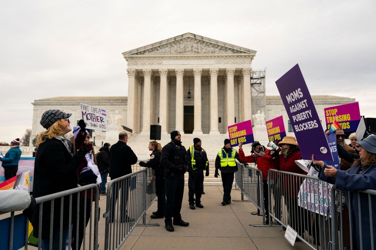 Police stand between demonstrators in support of gender-affirming treatment, left, and demonstrators in support of the Tennessee case against gender-affirming treatment for minors, right, outside the US Supreme Court in Washington, DC, on Wednesday.