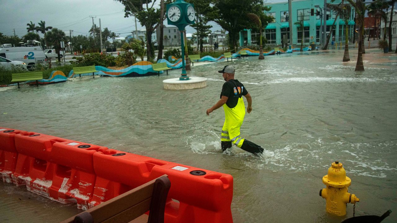 A man walks through a flooded Times Square area of Fort Myers Beach, Florida, on Thursday, September 26.