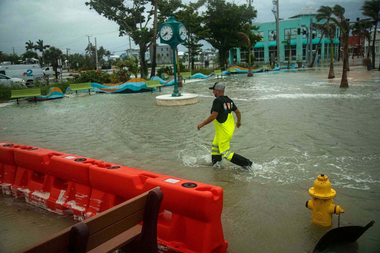 A man walks through a flooded Times Square area of Fort Myers Beach, Florida, on Thursday, September 26.