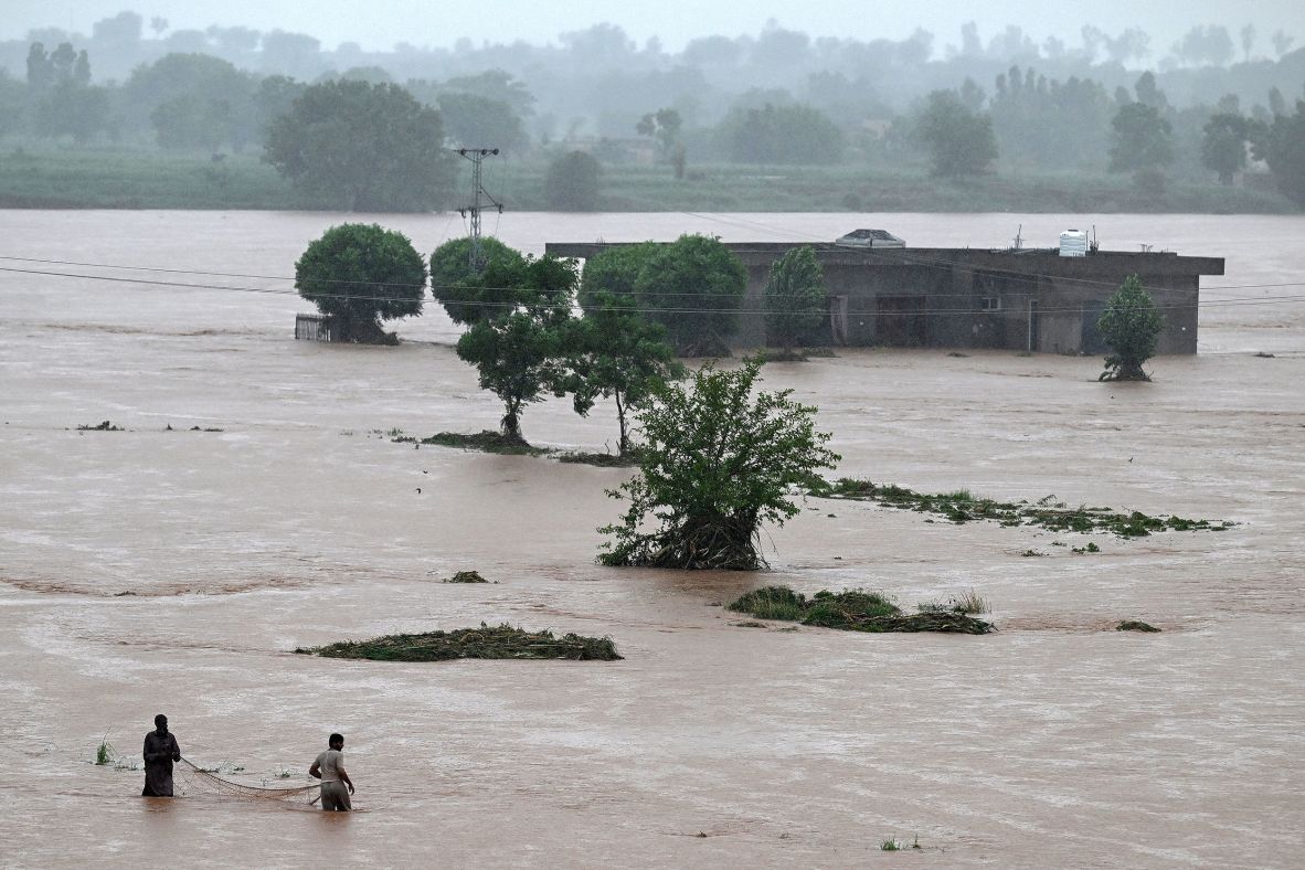 Local fishermen in floodwaters near a partially submerged house during heavy monsoon rains in Rawalpindi, a city in Punjab Province, Pakistan on July 17.