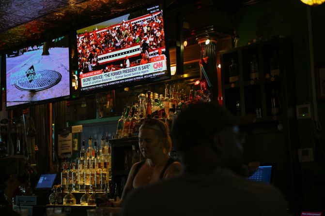 People watch CNN at Milwaukee Brat House in Milwaukee, Wisconsin, after President Donald Trump was rushed off stage after loud bangs were heard as he spoke at a rally in Pennsylvania on Saturday, July 13, 2024. The Secret Service says Trump is safe and under protective measures.