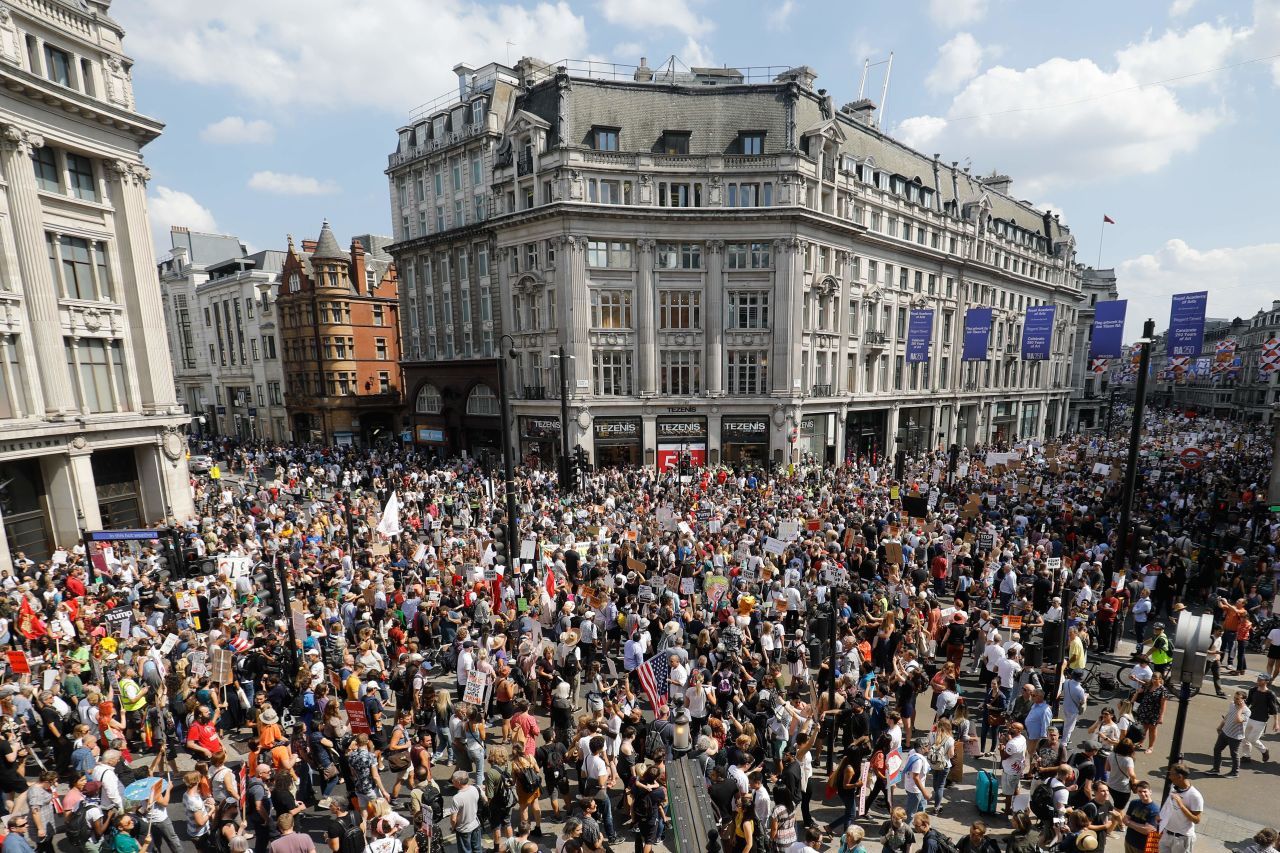 Protesters against the UK visit of Trump hold up placards as they take part in a march and rally in London