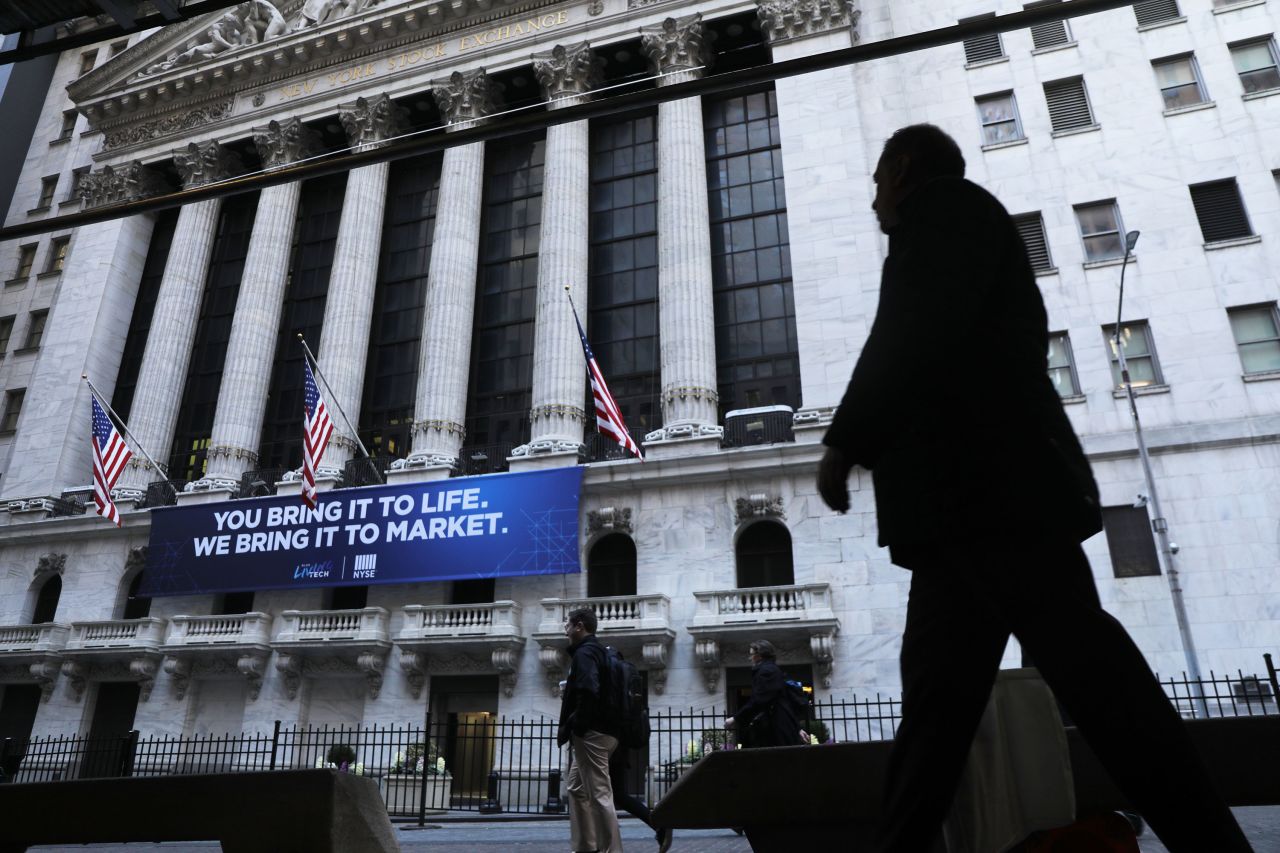 People walk by the New York Stock Exchange on March 9.