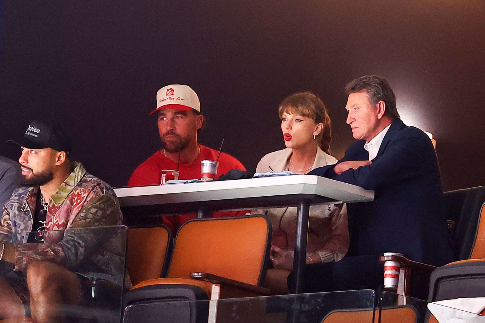 Swift and Kelce sit with NHL legend Wayne Gretzky as they watch a Stanley Cup Final game in Sunrise, Florida, in June 2025.