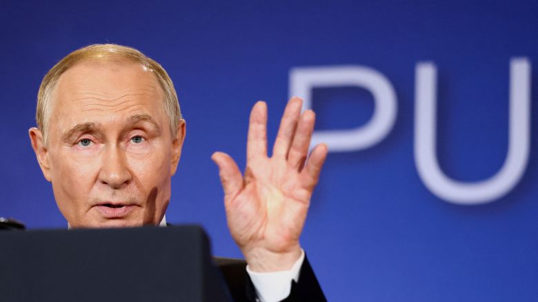 Russian President Vladimir Putin waves as he and US President Donald Trump (not pictured) conclude statements to the press after their Friday meeting in Alaska.