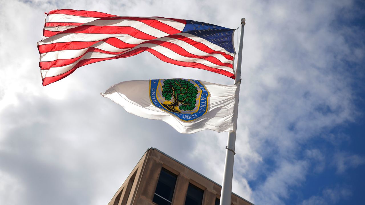 An American flag and Department of Education flag whip in the wind outside the department's headquarters in Washington, DC, on on March 6.