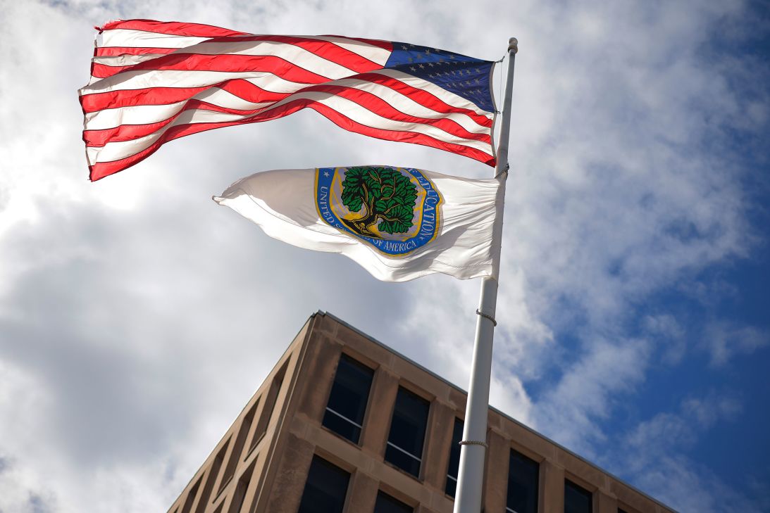 An American flag and Department of Education flag whip in the wind outside the department's headquarters in Washington, DC, on on March 6.