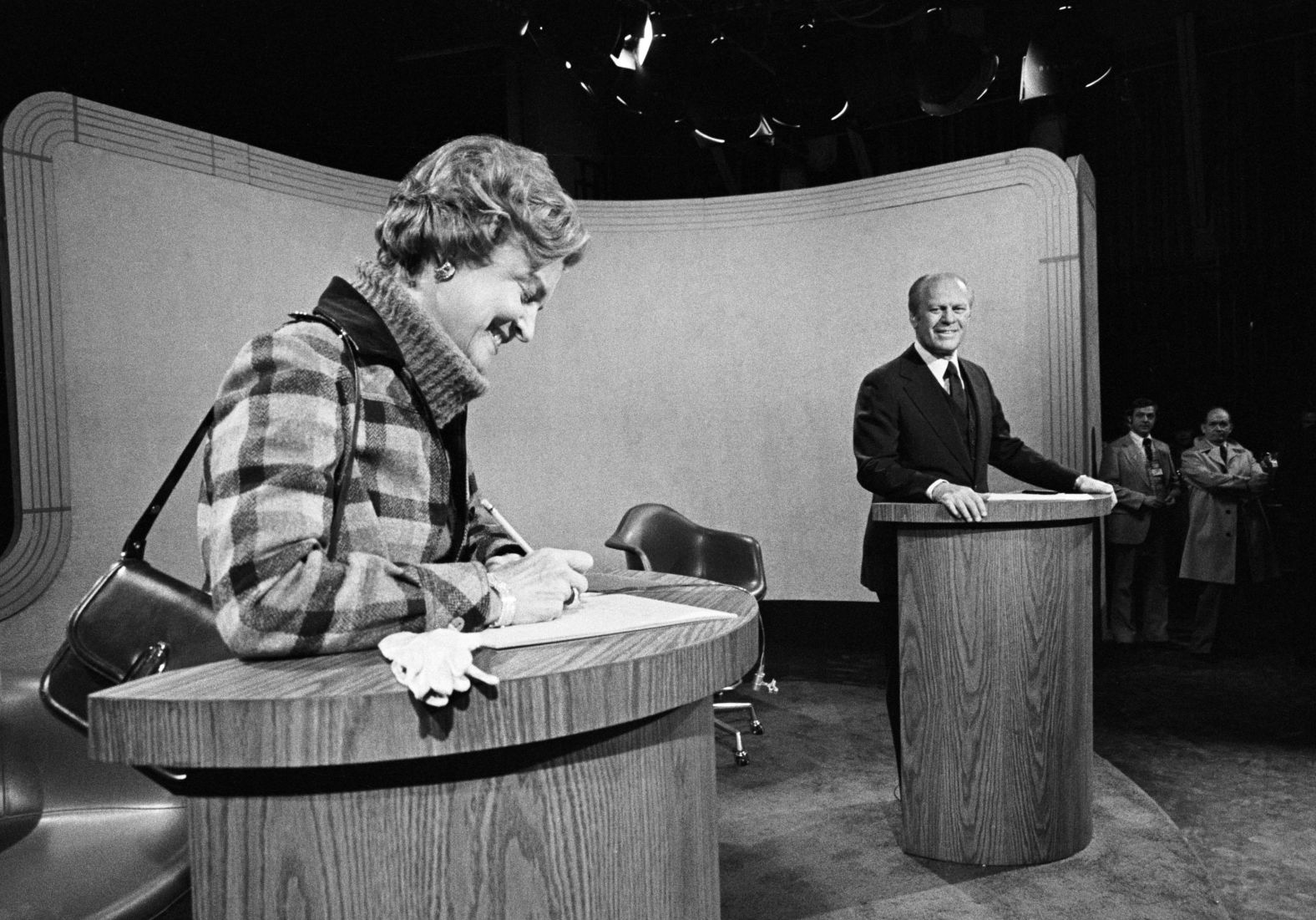 Ford watches his wife, Betty, write a note to Carter before their third debate in 1976. In her note, she wished Carter luck. Debate officials later removed the note and hand-delivered it to Carter.