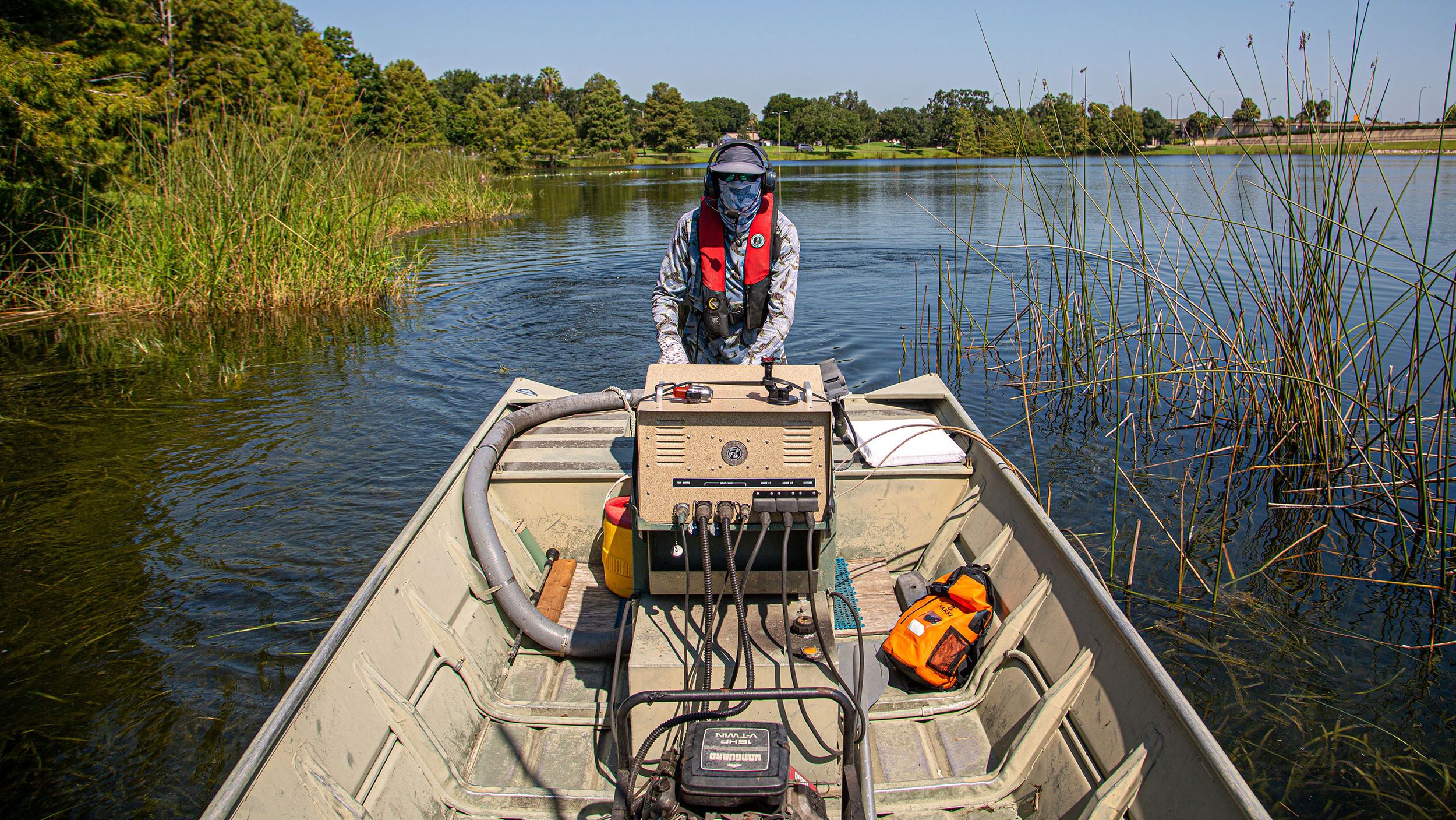 Howard Jelks, a retired USGS Fish Biologist, captains the electroshock boat hunting for the invasive Asian Swamp Eels in Orlando, Florida on July 29, 2025.