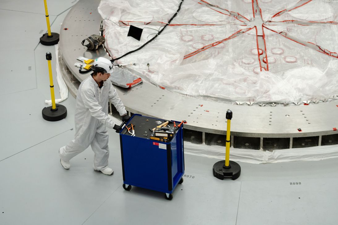 A person works on the cryostat base inside the tokamak hall at Commonwealth Fusion Systems.