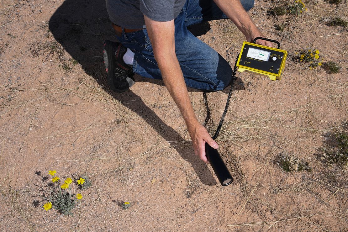 Bob Bell, a visitor at the Trinity Site during an open house in 2022, uses equipment to test for radioactivity at the White Sands Missile Range in New mexico.