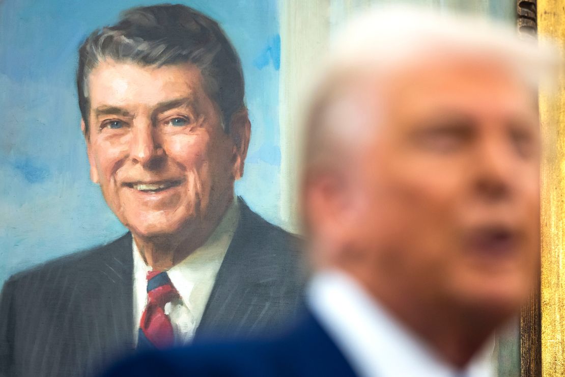 A painting of former President Ronald Reagan behind President Donald Trump during a swearing-in ceremony for Tulsi Gabbard in the Oval Office of the White House in Washington, DC on February 12. 