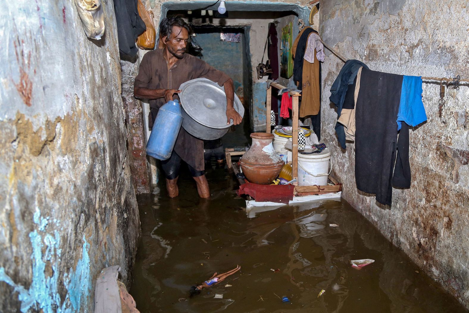 A resident collects his belongings from a flooded home in Hyderabad, Pakistan, on July 15.