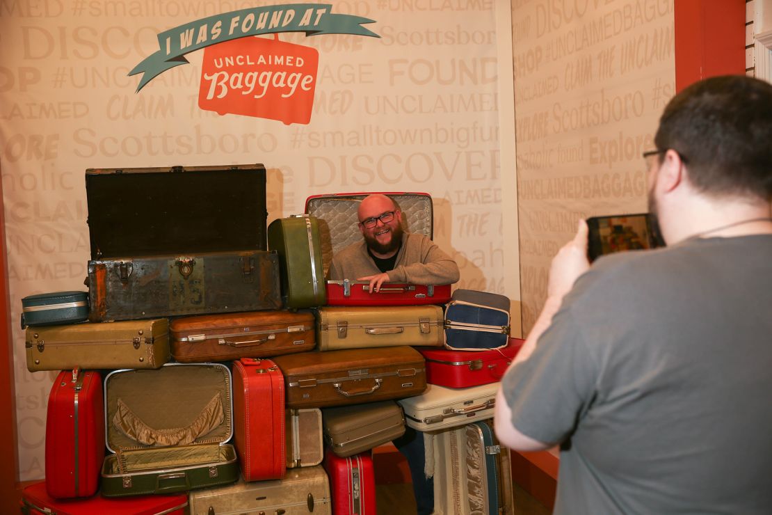 A man poses for a photo at Unclaimed Baggage in Scottsboro, Alabama. The store draws hundreds of thousands of visitors  annually.