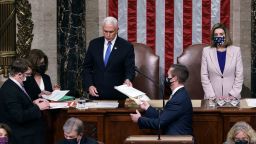Vice President Mike Pence hands the West Virginia certification to staff as Speaker of the House Nancy Pelosi, D-Calif., listen during a joint session of Congress after working through the night, at the Capitol on January 7, 2021 in Washington, DC.