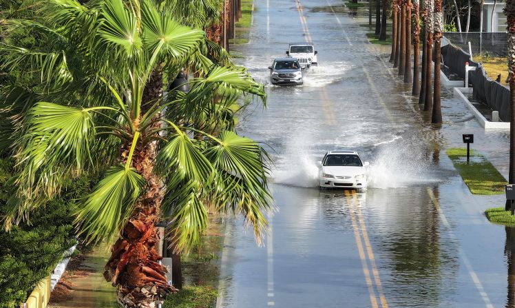 Cars drive through a flooded street in St. Pete Beach on September 26.