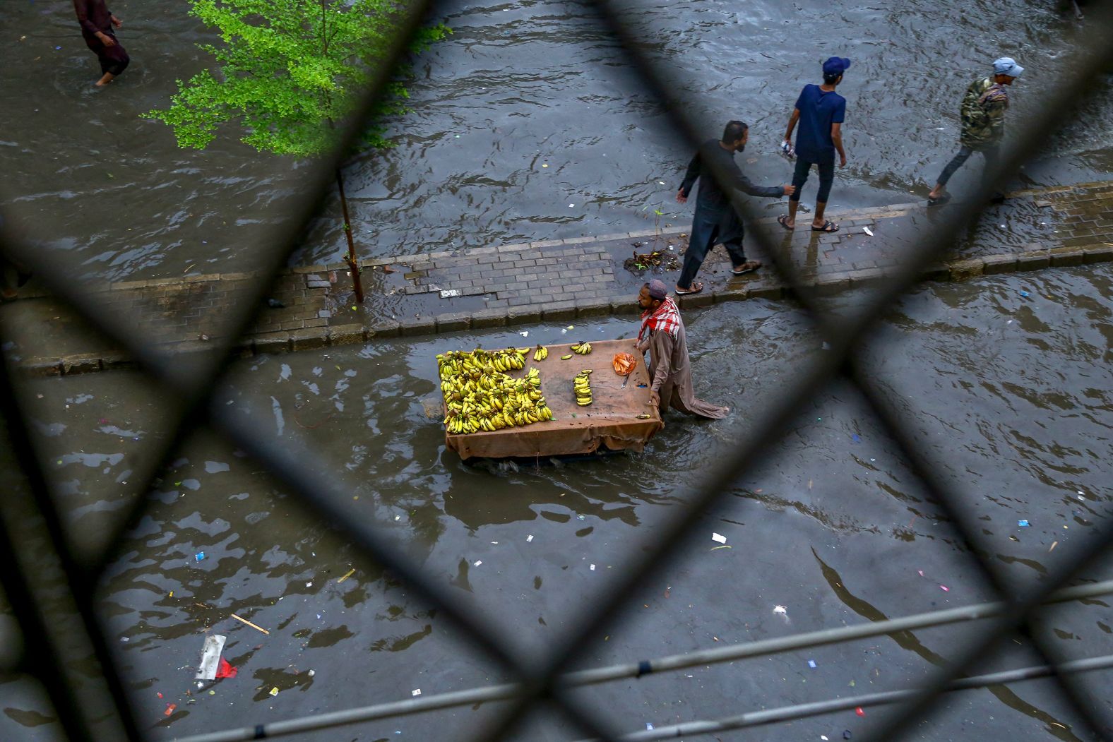 A man pushes a cart through the flooded streets of Hyderabad, Pakistan, on July 14.