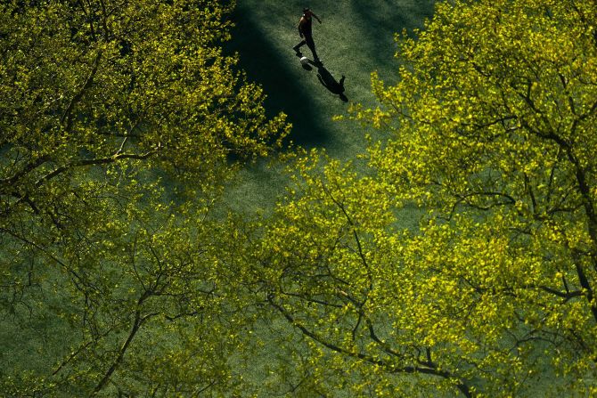 A person kicks a soccer ball around Columbus Park in New York on Thursday, April 24.