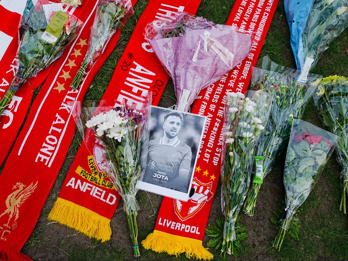 A portrait of Jota is placed near scarves and flowers at Anfield on Friday.