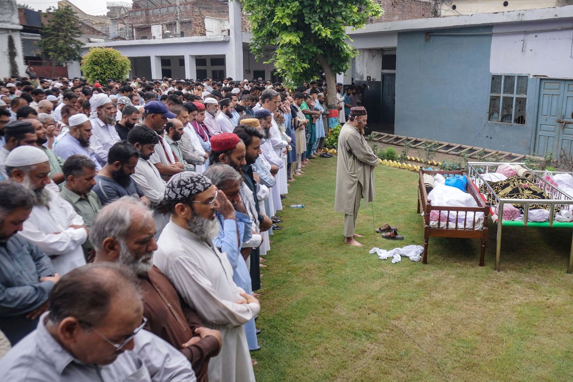 Residents and relatives pray for flash flood victims during a funeral in Sialkot, Punjab province, Pakistan, on June 28.