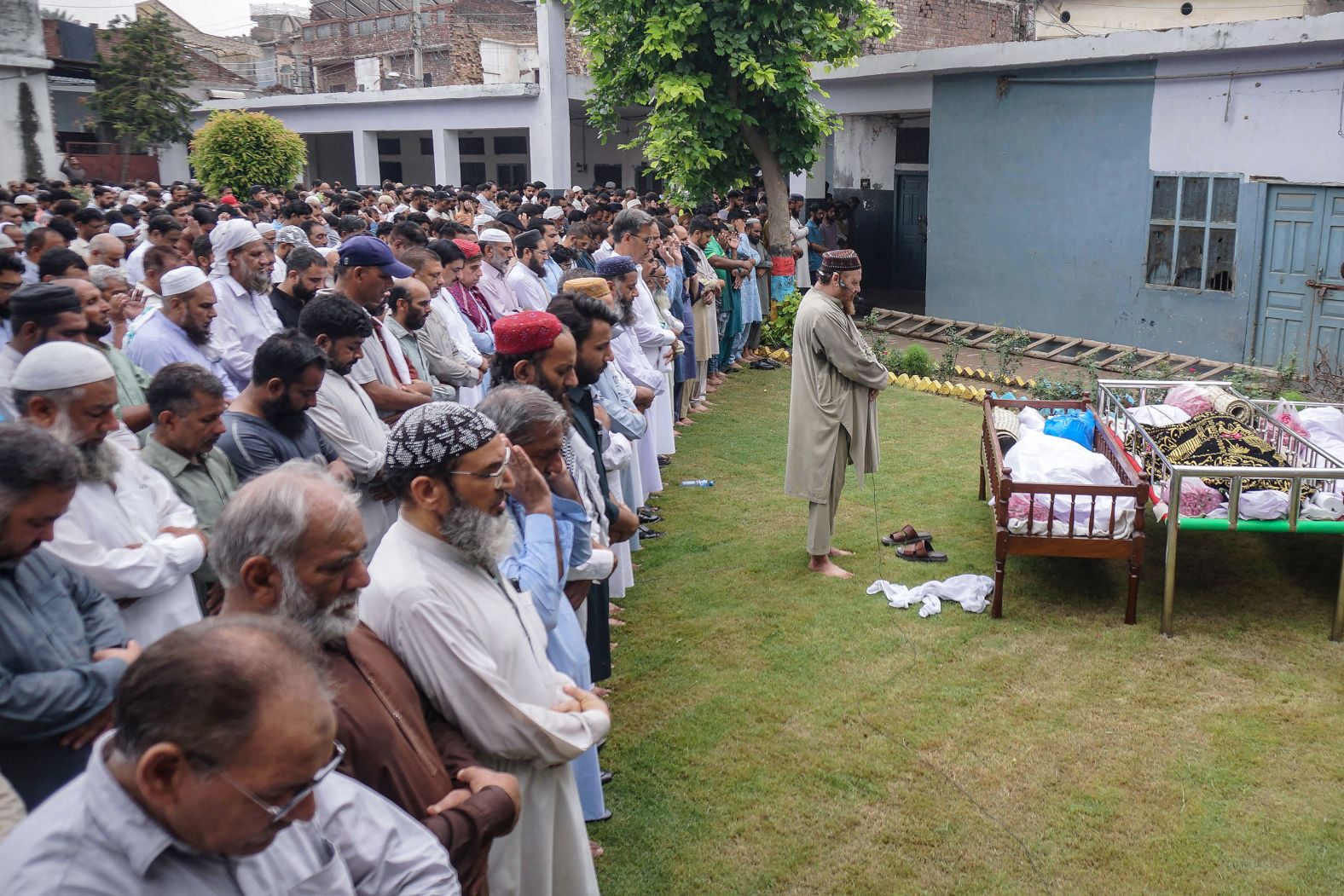 Residents and relatives pray for flash flood victims during a funeral in Sialkot, Punjab province, Pakistan, on June 28.
