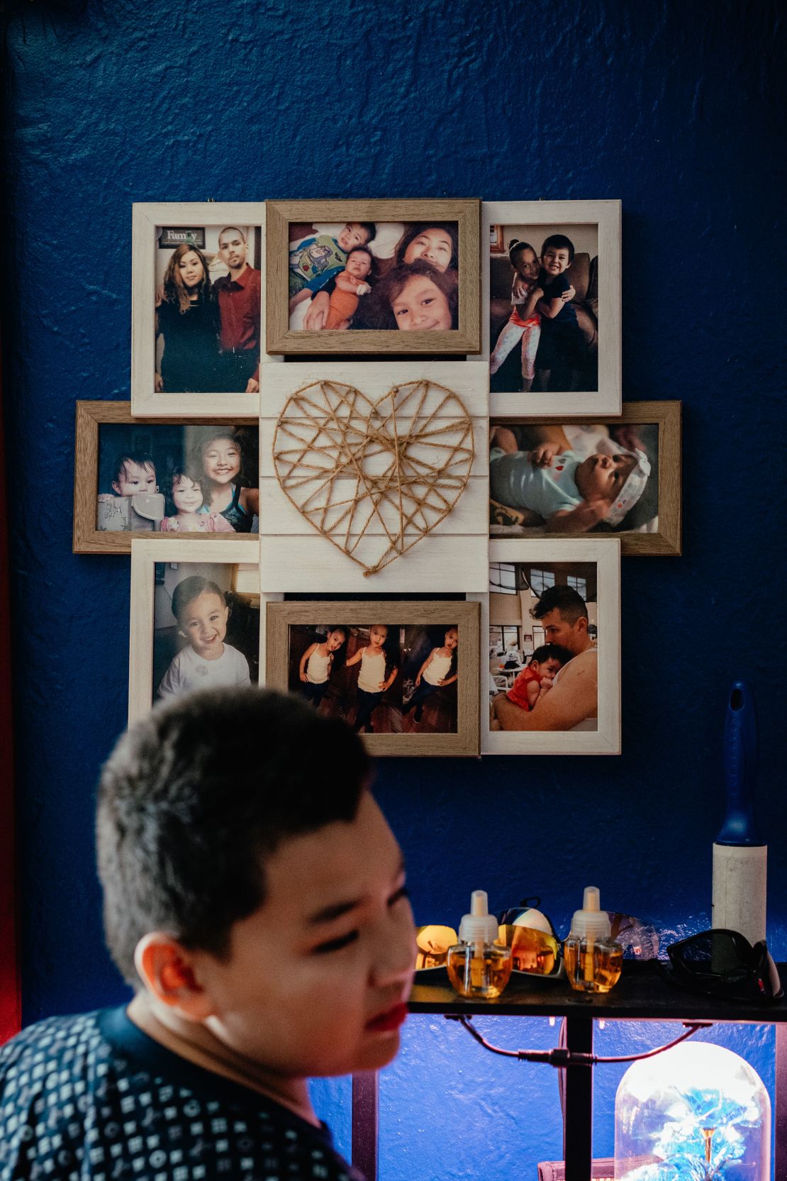 Yang's son Michael stands by framed photos of his family at his grandparents’ home.