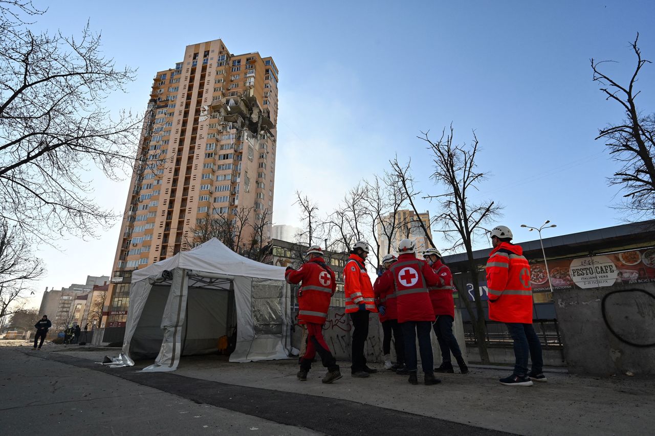 Medics gather near a residential apartment block which was struck by a missile or rocket fire in Kyiv, on February 26. 
