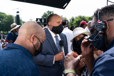 Martin Luther King III, second from left, prepares for a television interview at the March on Washington on August 28.