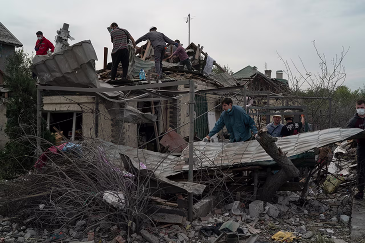 Volunteers work to clean the debris on a site where several houses were destroyed after a Russian attack at a residential area in Zaporizhzhia, Ukraine, Sunday, October 9.