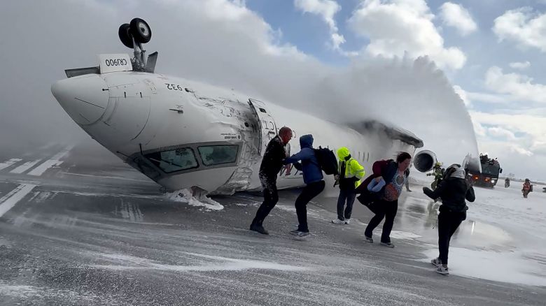 Passengers leave a Delta Air Lines CRJ-900 jet after it crashed on landing at Toronto Pearson International Airport in Mississauga, Ontario, Canada February 17, 2025 in a still image from video.  Peter Koukov/Handout via REUTERS 
THIS IMAGE HAS BEEN SUPPLIED BY A THIRD PARTY