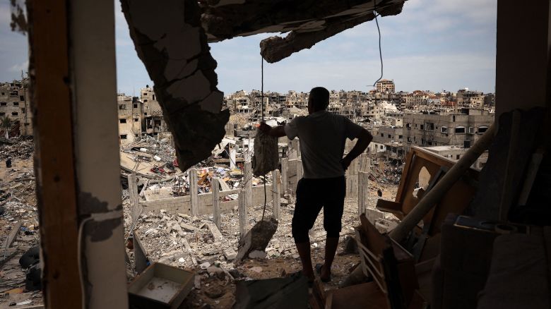TOPSHOT - A Palestinian man looks at a ravaged neighbourhood from a destroyed apartment in Khan Yunis in the southern Gaza Strip on May 2, 2024, amid the ongoing conflict between Israel and the Hamas movement. (Photo by AFP) (Photo by -/AFP via Getty Images)